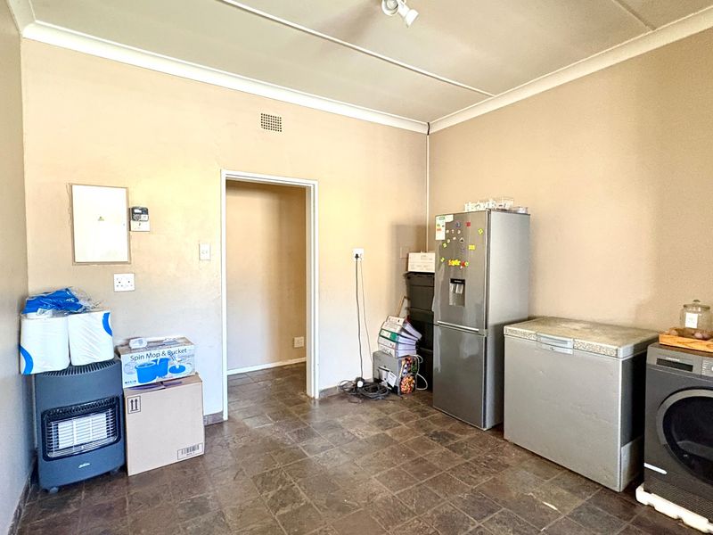 A functional laundry area featuring tiled flooring, coved ceilings, and an electrical distribution board, providing a practical space for utility and appliance storage.