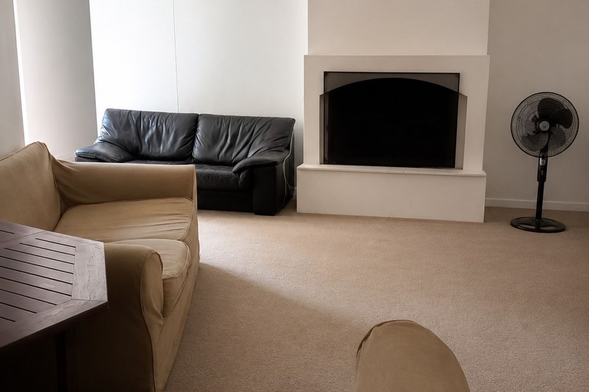 A living room featuring a central built-in fireplace and neutral carpeting, offering a blank canvas for interior design updates.