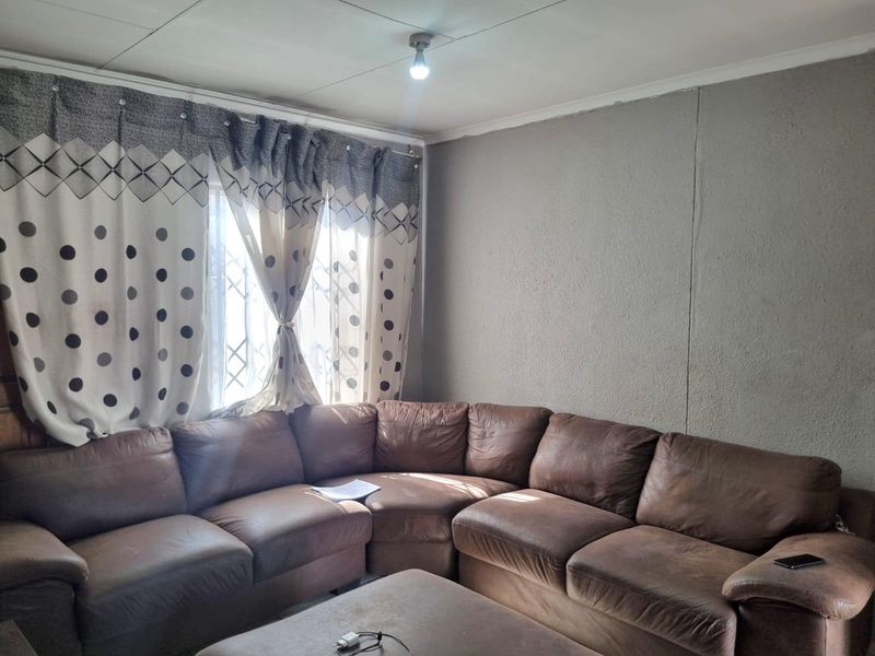 A living room featuring a window with a security gate and textured wall finishes.