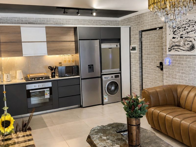 Modern open-plan living area featuring a sleek kitchen with integrated appliances, contemporary cabinetry, and stylish brick-effect wall finishes.