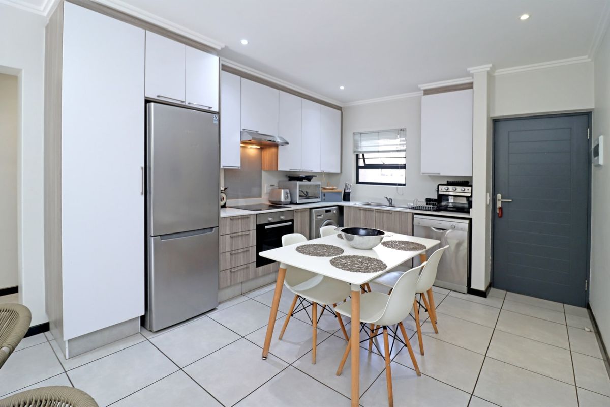 Modern kitchen featuring sleek built-in cabinetry, integrated appliances, tiled flooring, and recessed lighting, offering a functional and contemporary cooking space.