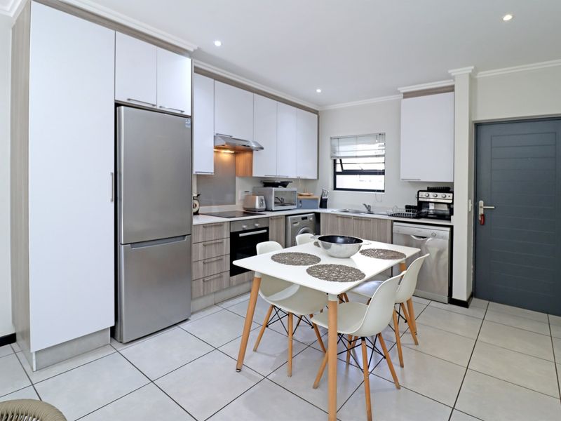 Modern kitchen featuring sleek built-in cabinetry, integrated appliances, tiled flooring, and recessed lighting, offering a functional and contemporary cooking space.