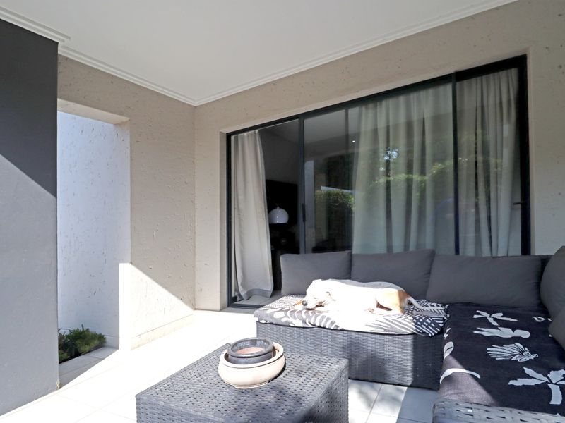 A covered patio area featuring tiled flooring and large sliding glass doors providing access to the interior living space.