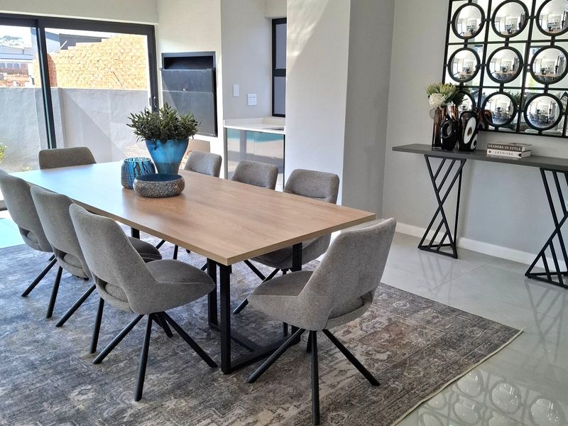 Modern dining area featuring recessed ceiling lighting, large sliding glass doors, built-in fireplace, and polished porcelain floor tiles.