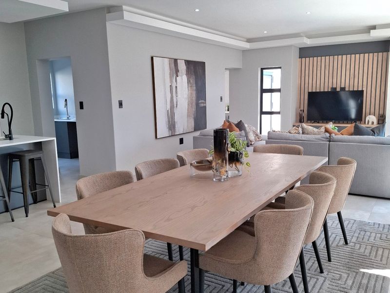 Spacious open-plan living and dining area featuring modern finishes, recessed lighting, a feature slat wall, and a seamless transition to the kitchen.