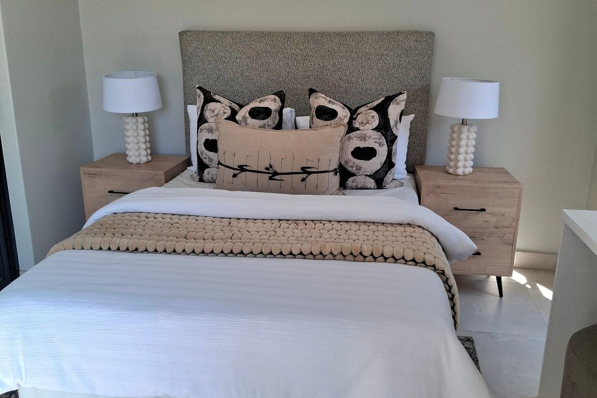 A well-maintained bedroom featuring neutral wall tones and tiled flooring, providing a clean and comfortable living space.