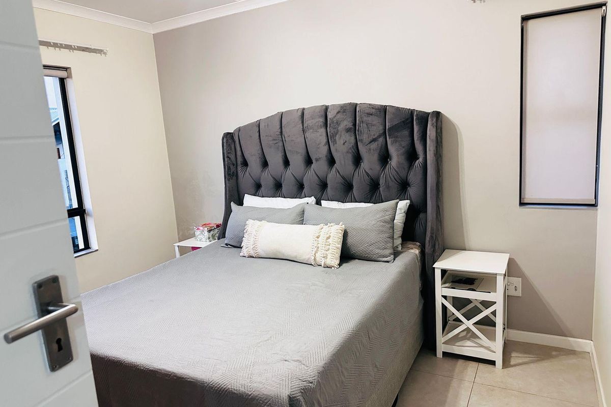 A well-maintained bedroom featuring neutral wall tones, tiled flooring, and modern finishes, providing a comfortable and functional living space.