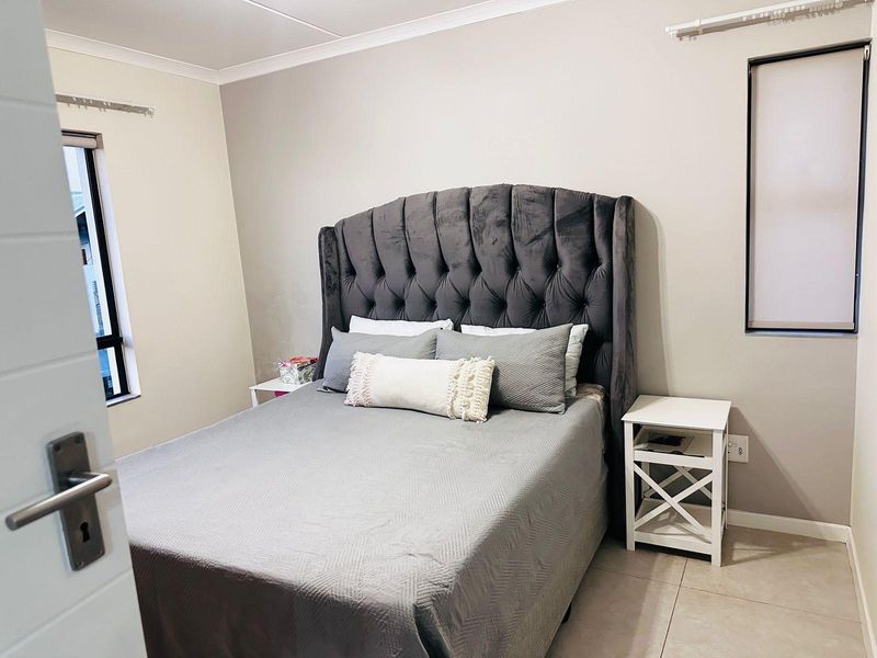 A well-maintained bedroom featuring neutral wall tones, tiled flooring, and modern finishes, providing a comfortable and functional living space.