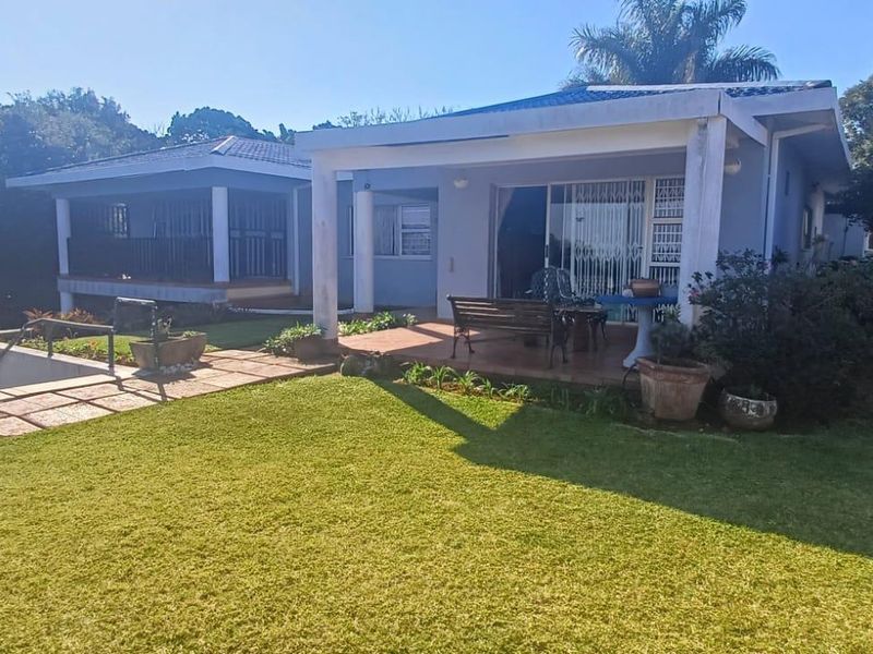 Rear view of the house featuring a covered patio, tiled flooring, and direct access to a well-maintained garden area.