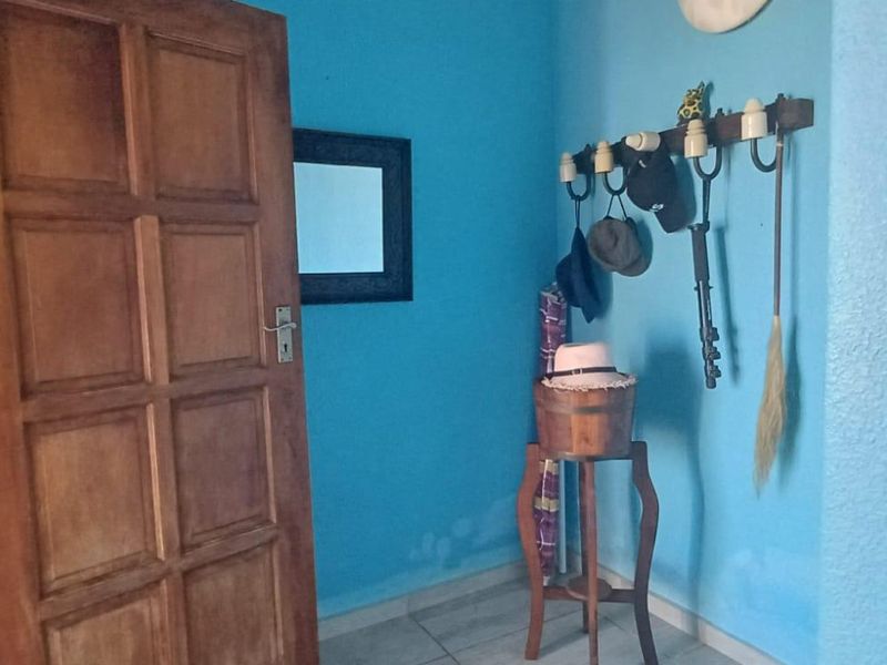 An entry area featuring a solid wood door and tiled flooring, showing signs of moisture damage on the lower wall section.