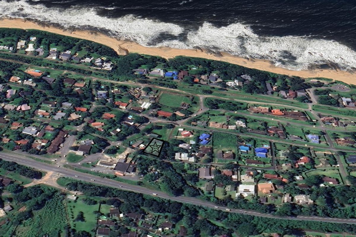 Aerial view of a residential vacant land plot located in a coastal neighborhood, highlighting its proximity to the beach and surrounding infrastructure.