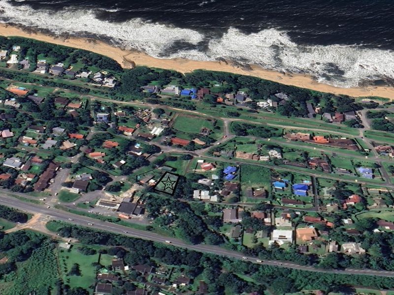 Aerial view of a residential vacant land plot located in a coastal neighborhood, highlighting its proximity to the beach and surrounding infrastructure.