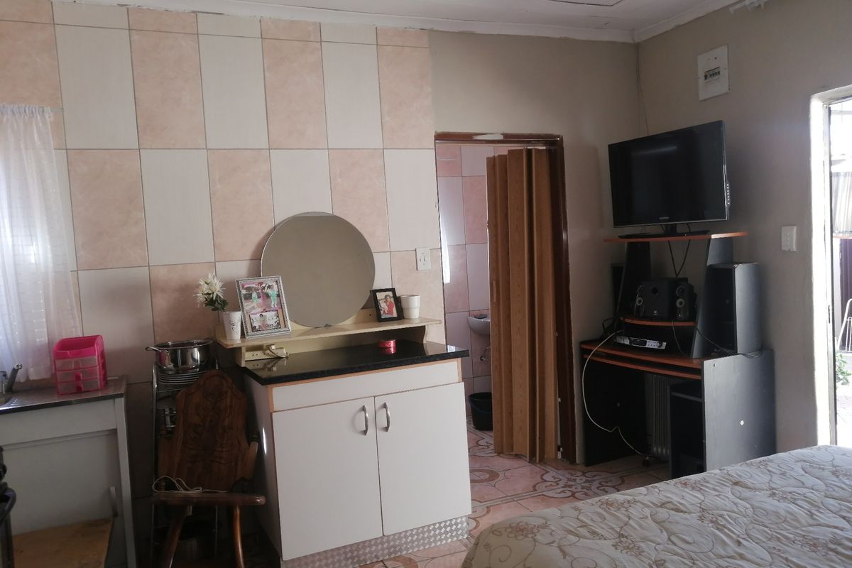 A bedroom featuring tiled wall accents, tiled flooring, and a folding door leading to an adjacent space.