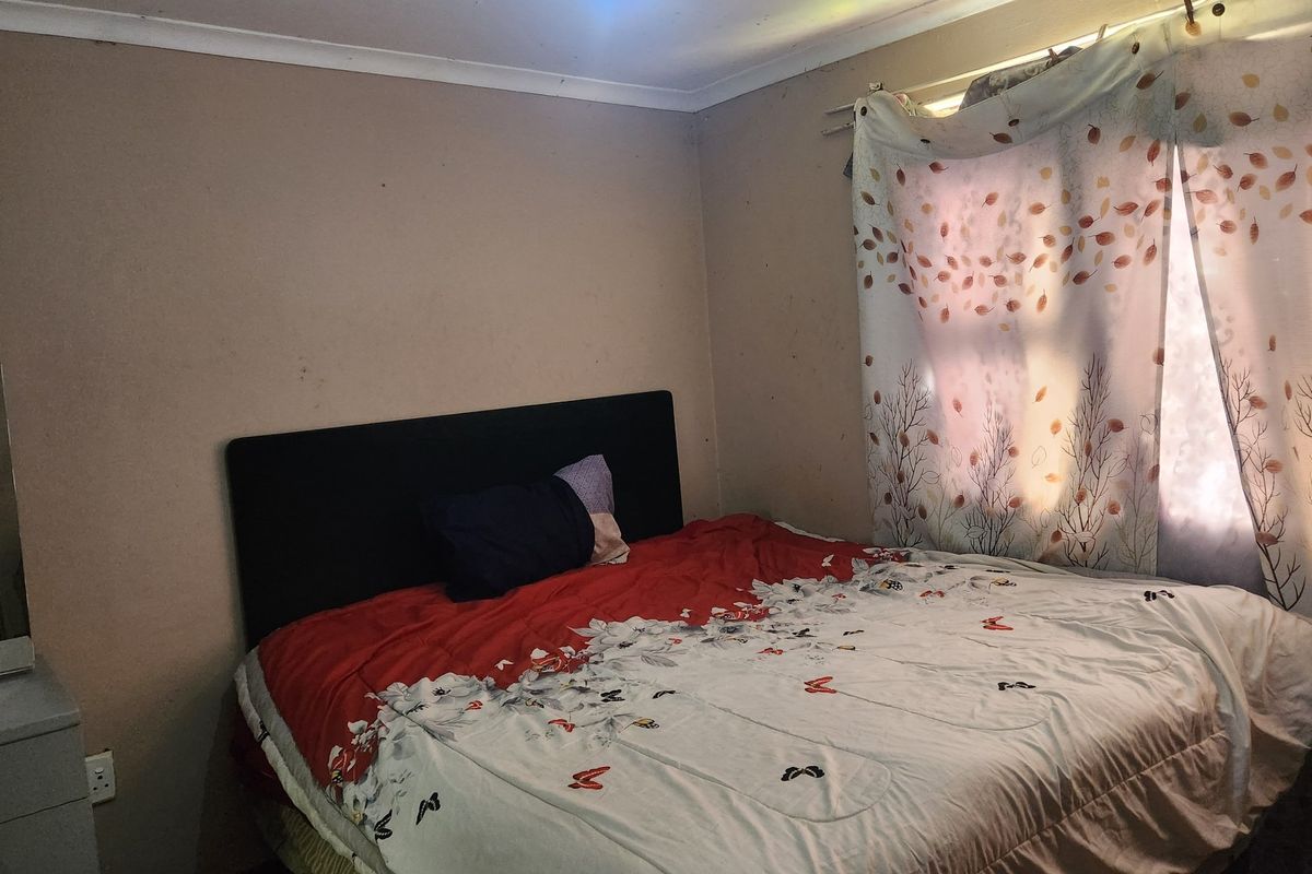 A bedroom featuring standard finishes, requiring cosmetic updates to the walls and ceiling to improve the overall condition and appeal of the space.