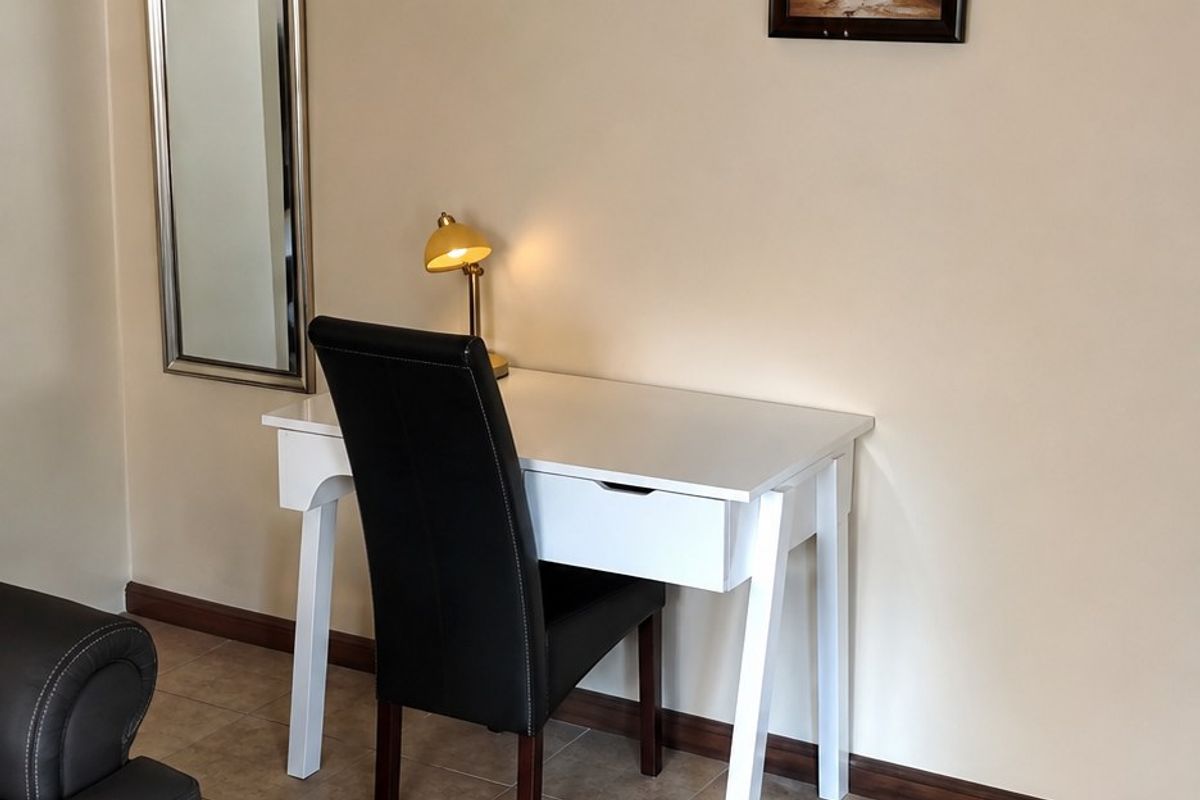 A living area featuring neutral wall tones, ceramic floor tiles, and decorative coving, providing a clean and functional space.