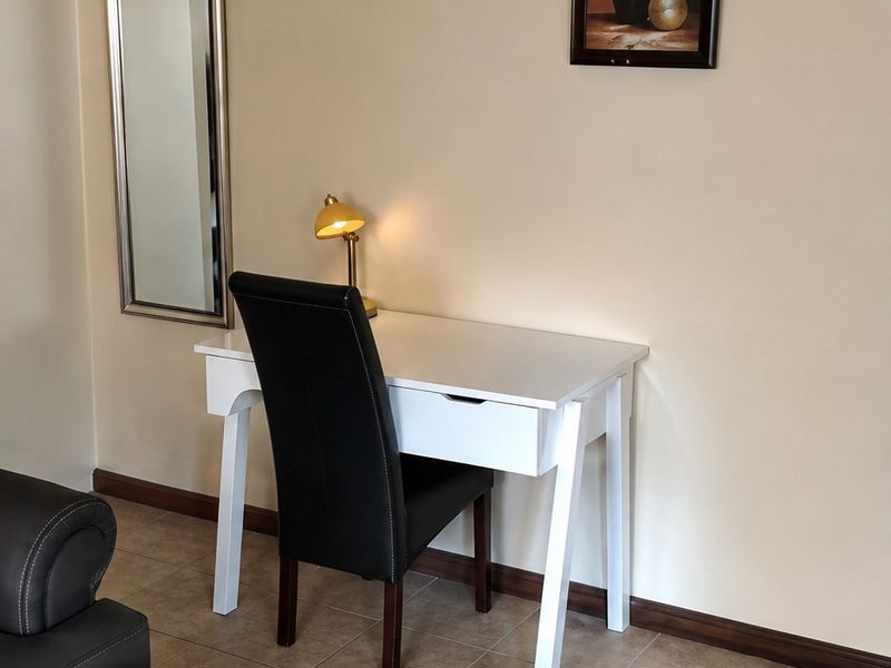 A living area featuring neutral wall tones, ceramic floor tiles, and decorative coving, providing a clean and functional space.