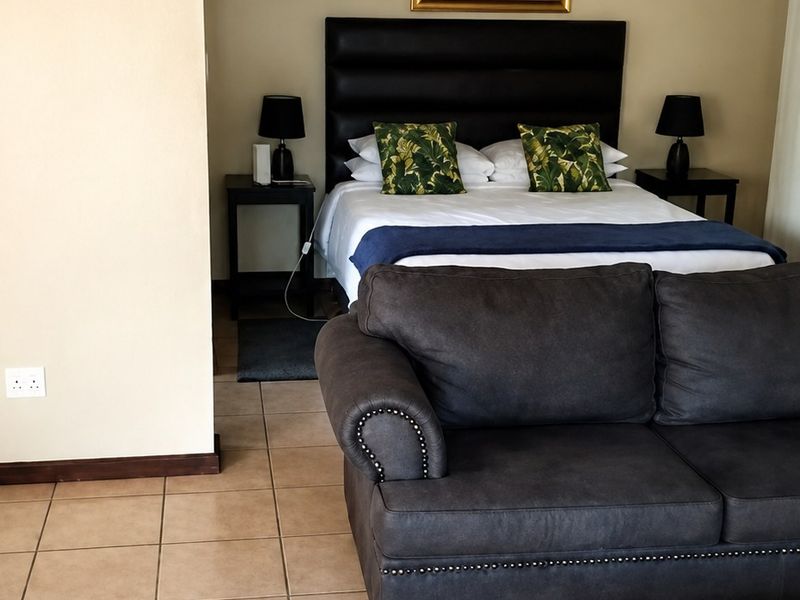 A bedroom featuring tiled flooring and neutral wall finishes, providing a functional space with integrated lighting and coved ceiling detailing.