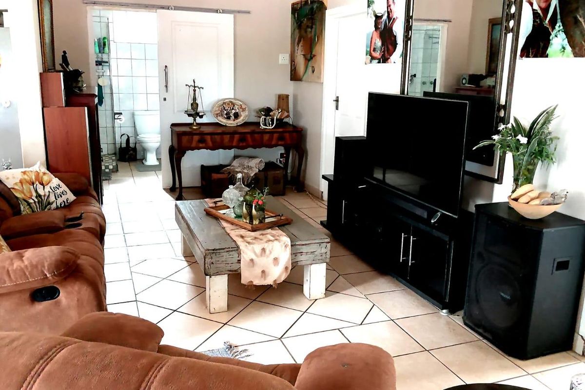 A living room area featuring tiled flooring and a sliding door leading to an adjacent bathroom.