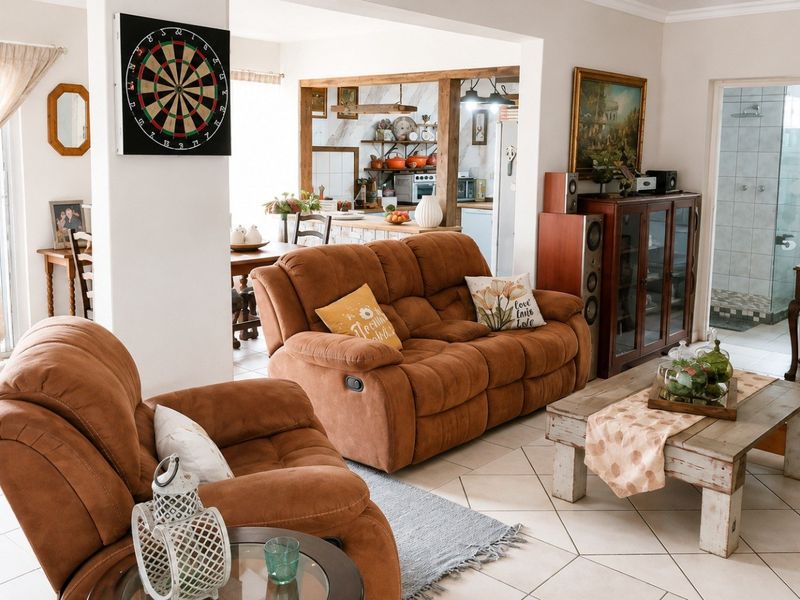Open plan living area featuring tiled flooring, connecting to a kitchen space and a bathroom with a shower enclosure.