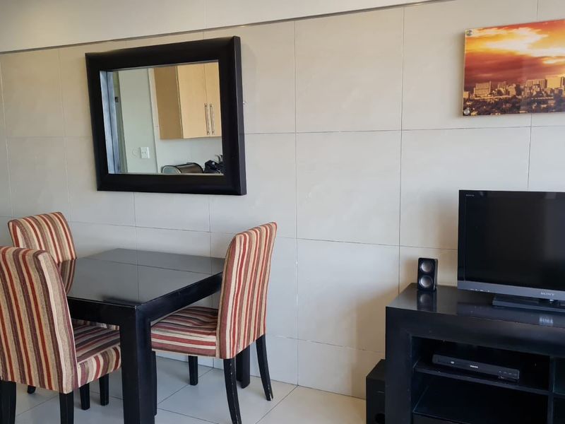 A living area featuring large format wall tiles and a wall-mounted prepaid electricity meter.