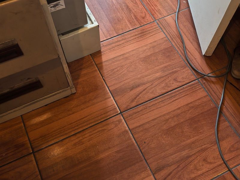 A close-up view of wood-look ceramic floor tiles installed in a residential interior space.