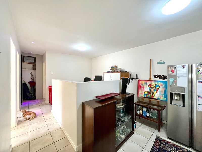Open plan living area featuring tiled flooring, recessed lighting, and a built-in storage cupboard, providing a versatile space for various living arrangements.
