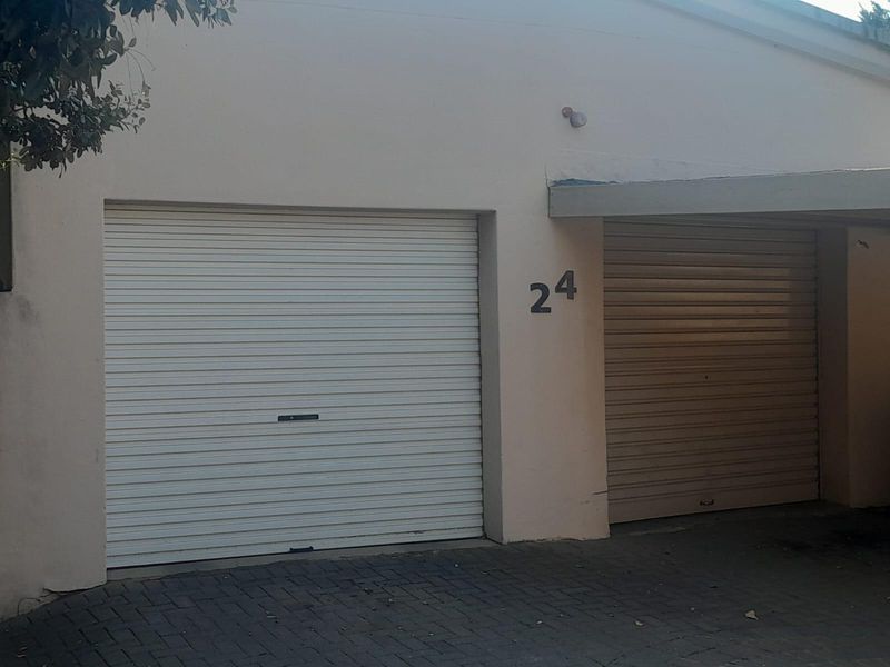 A double garage exterior featuring roller shutter doors and a paved driveway area.