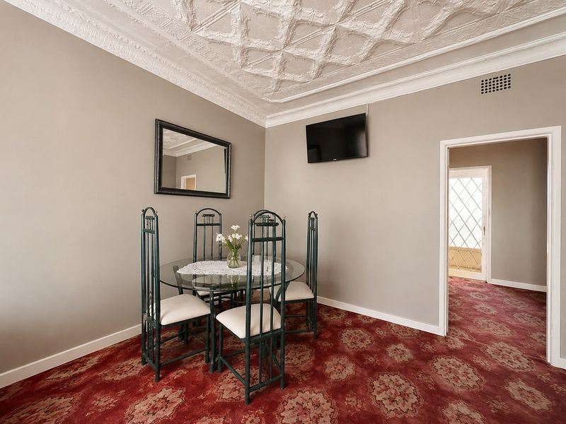 Dining room featuring an ornate plaster ceiling, patterned carpet, and coving, providing a classic architectural foundation for potential updates.