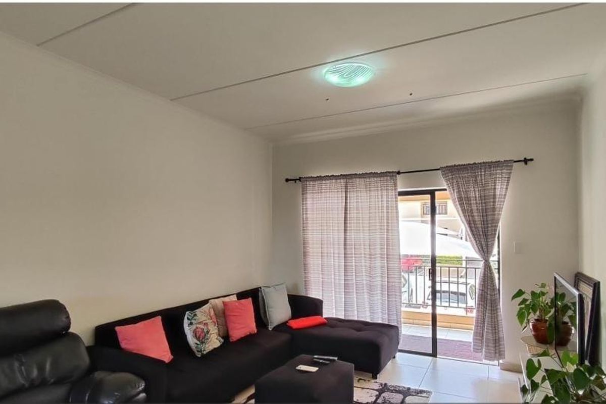 A living room featuring tiled flooring and a sliding glass door providing access to an outdoor area.