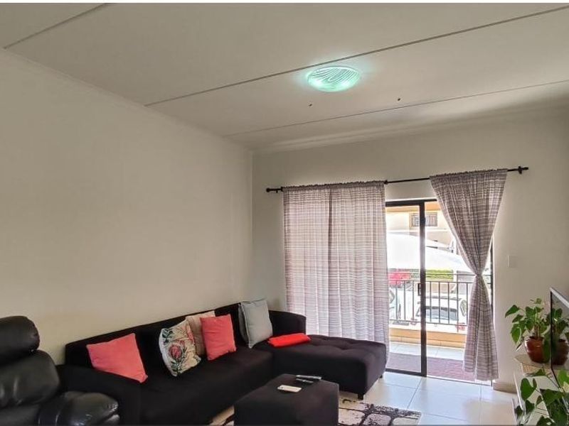A living room featuring tiled flooring and a sliding glass door providing access to an outdoor area.