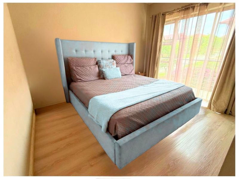 A bedroom featuring laminate flooring and a large sliding glass door providing natural light.