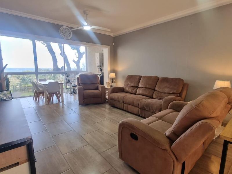 Spacious open-plan living area featuring large sliding glass doors that provide natural light and access to the outdoor space.