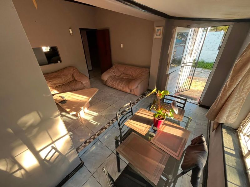 Open plan living and dining area featuring tiled flooring and direct access to the exterior through a security gate.