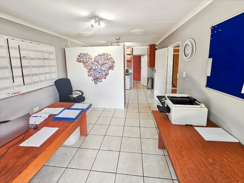A functional office space featuring ceramic floor tiles, coving, and a partition wall, providing a practical layout for a home workspace.