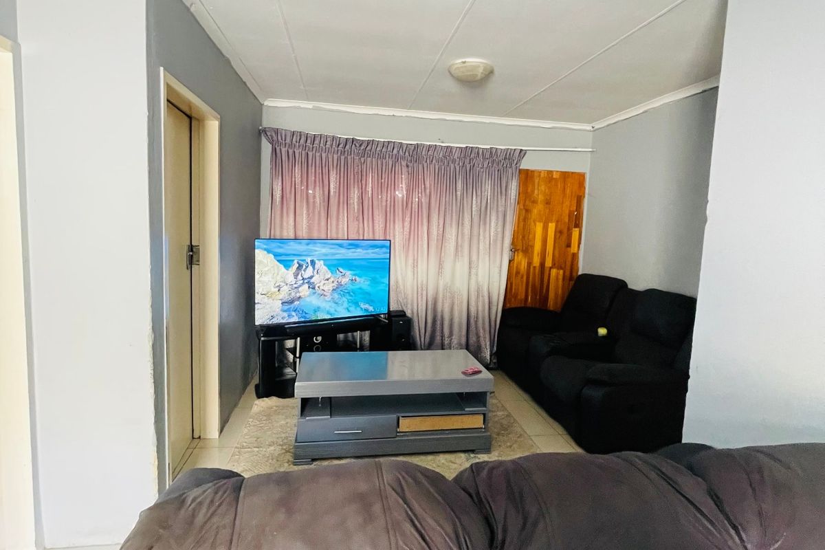 A living room featuring tiled flooring and coved ceilings, providing a functional space for relaxation.