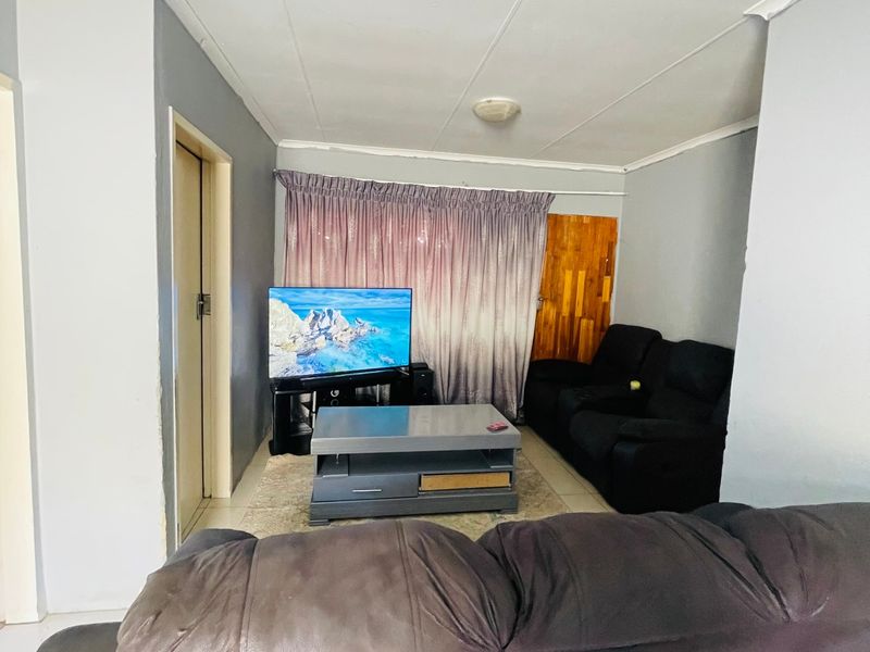 A living room featuring tiled flooring and coved ceilings, providing a functional space for relaxation.