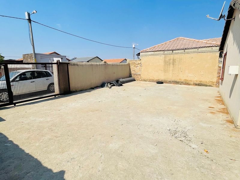A spacious, paved rear courtyard area enclosed by boundary walls, offering potential for landscaping or outdoor utility space.