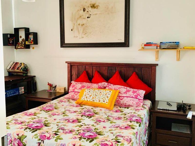 A functional bedroom featuring tiled flooring and neutral wall finishes, providing a comfortable space for rest.