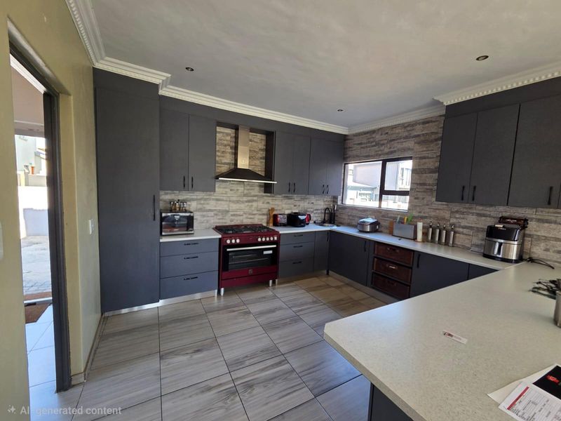 Modern kitchen featuring dark grey cabinetry, stone-look backsplash, gas stove with extractor fan, and light-toned tiled flooring.