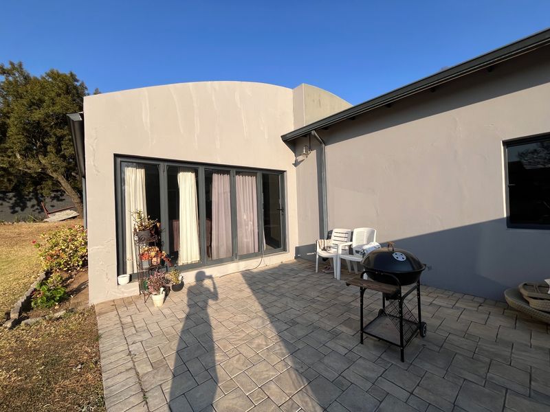 A paved outdoor patio area featuring modern bi-fold doors providing seamless access to the interior living space.