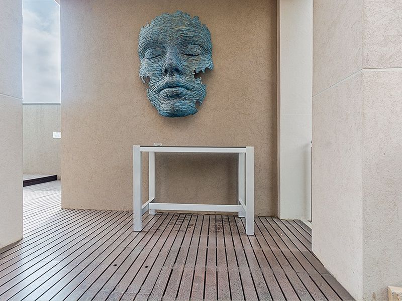 A modern balcony area featuring high-quality timber decking and textured wall finishes, providing a clean and minimalist outdoor space.