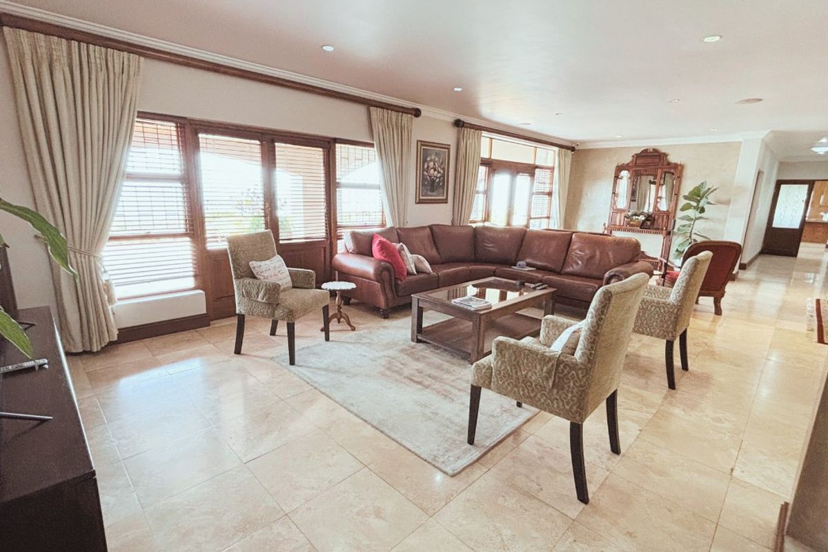 Spacious living room featuring large timber-framed sliding doors, tiled flooring, and recessed downlighting, offering a bright and comfortable atmosphere.
