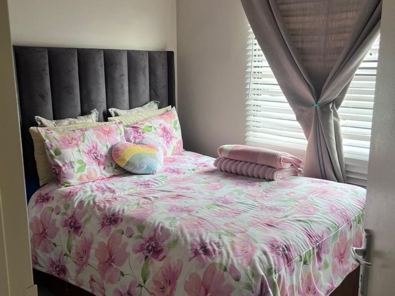 A cozy bedroom featuring tiled flooring and venetian blinds, providing a clean and functional space.