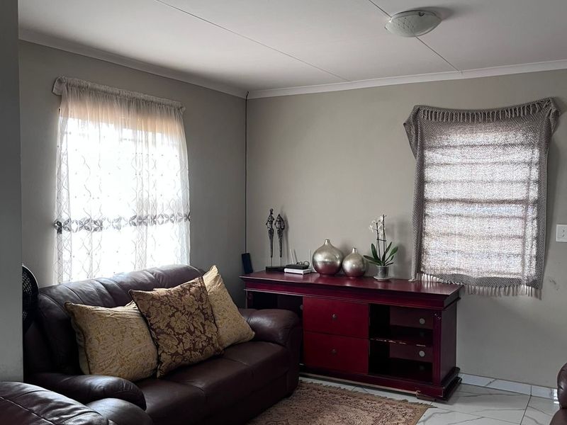 A living room featuring tiled flooring and neutral wall finishes, providing a functional space for relaxation.
