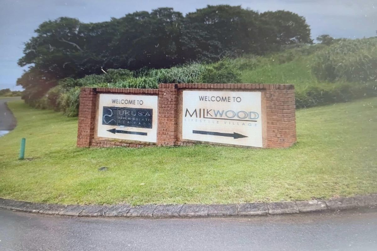 Entrance signage for Milkwood Lifestyle Village and Ukusa River Estate, featuring a brick-built monument sign situated on a landscaped verge.