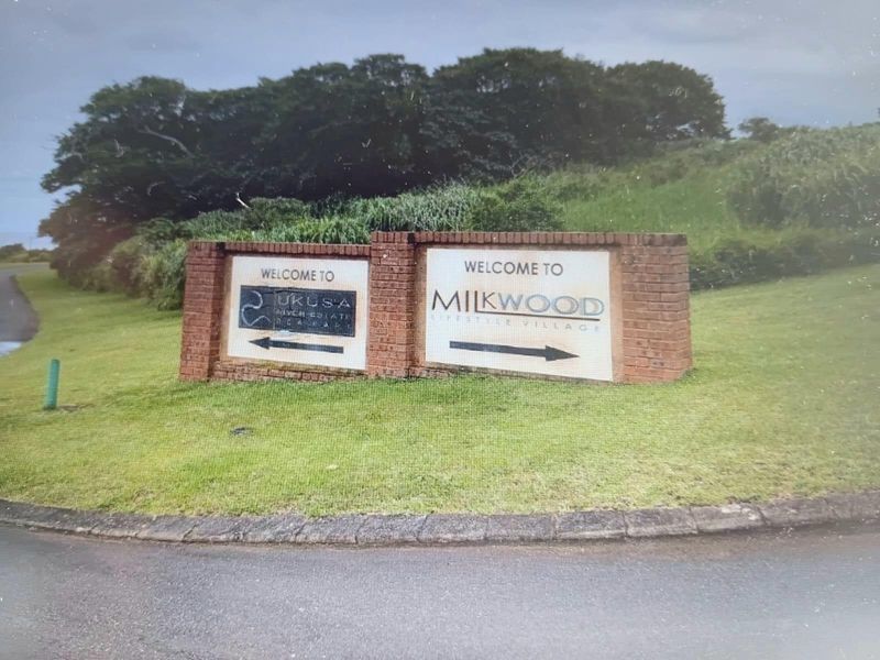 Entrance signage for Milkwood Lifestyle Village and Ukusa River Estate, featuring a brick-built monument sign situated on a landscaped verge.