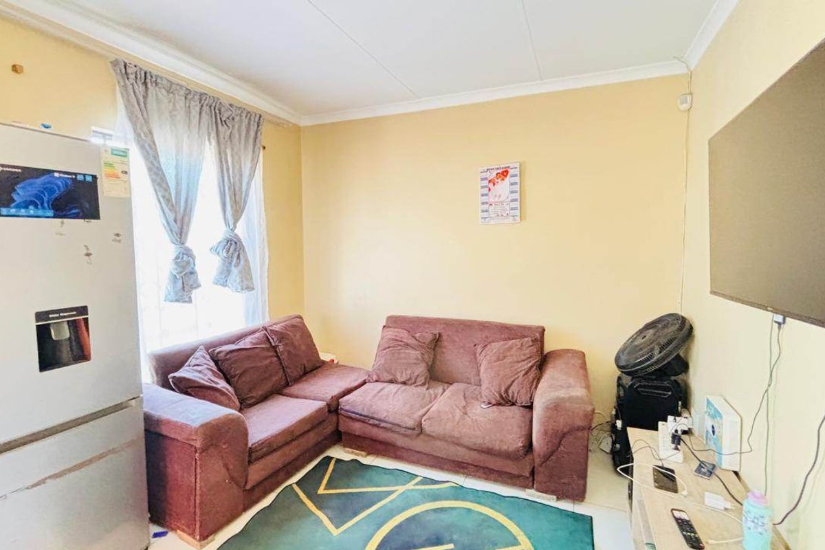 A living room featuring tiled flooring and coved ceiling details, providing a functional space for relaxation.