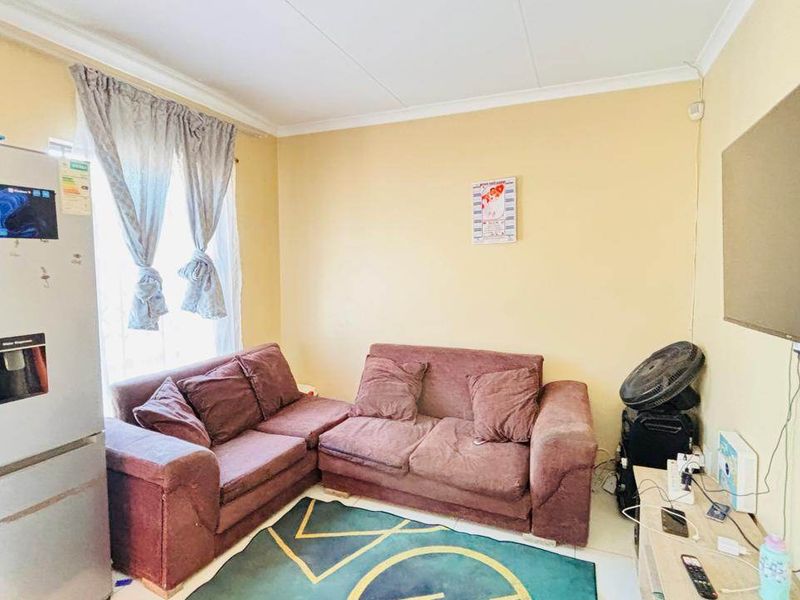 A living room featuring tiled flooring and coved ceiling details, providing a functional space for relaxation.