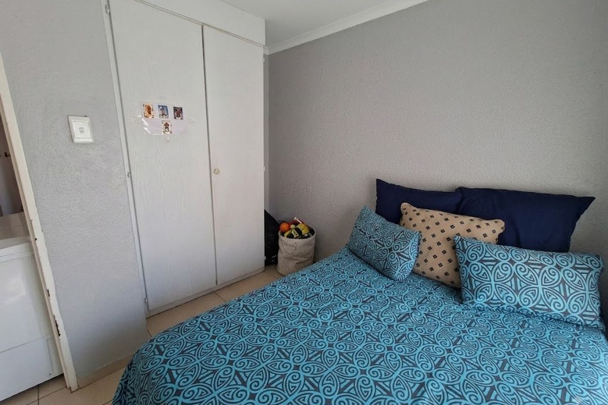 A bedroom featuring tiled flooring, a built-in wardrobe, and coved ceiling details.