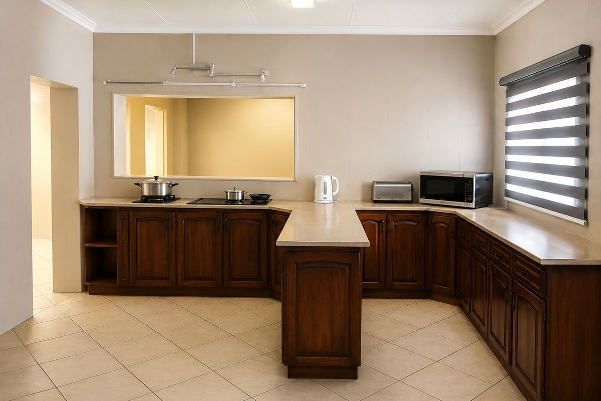 A well-maintained kitchen featuring dark wood cabinetry, stone countertops, ceramic tile flooring, and a convenient pass-through window to the adjacent room.